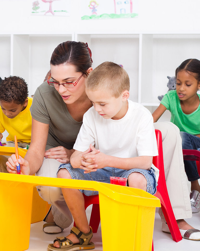 teacher helping student at desk